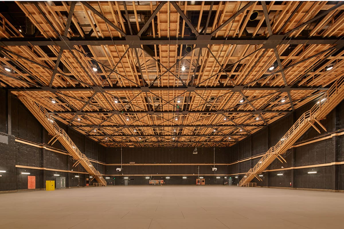 An empty sound stage at The Burbank Studios with exposed timber trusses and a lighting grid